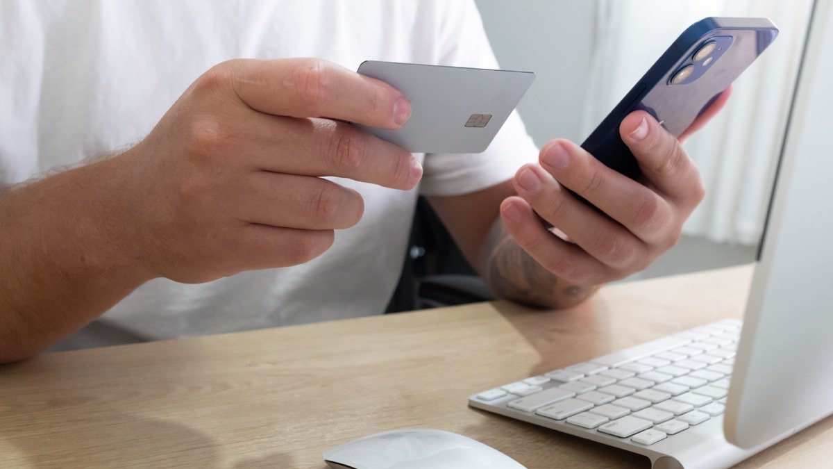手持信用卡與手機準備進行網上付款